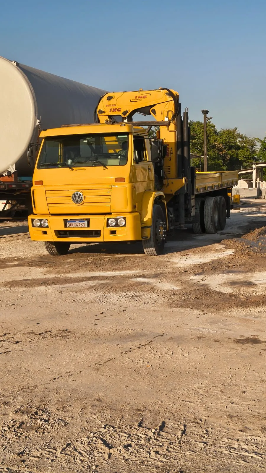 Caminhão Munck amarelo da Batista Munck em operação num pátio industrial
