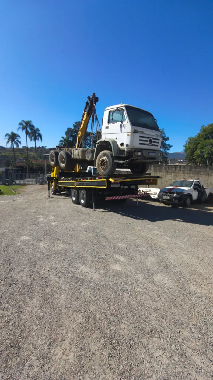 Transporte de veículo pesado sobre prancha em área rural